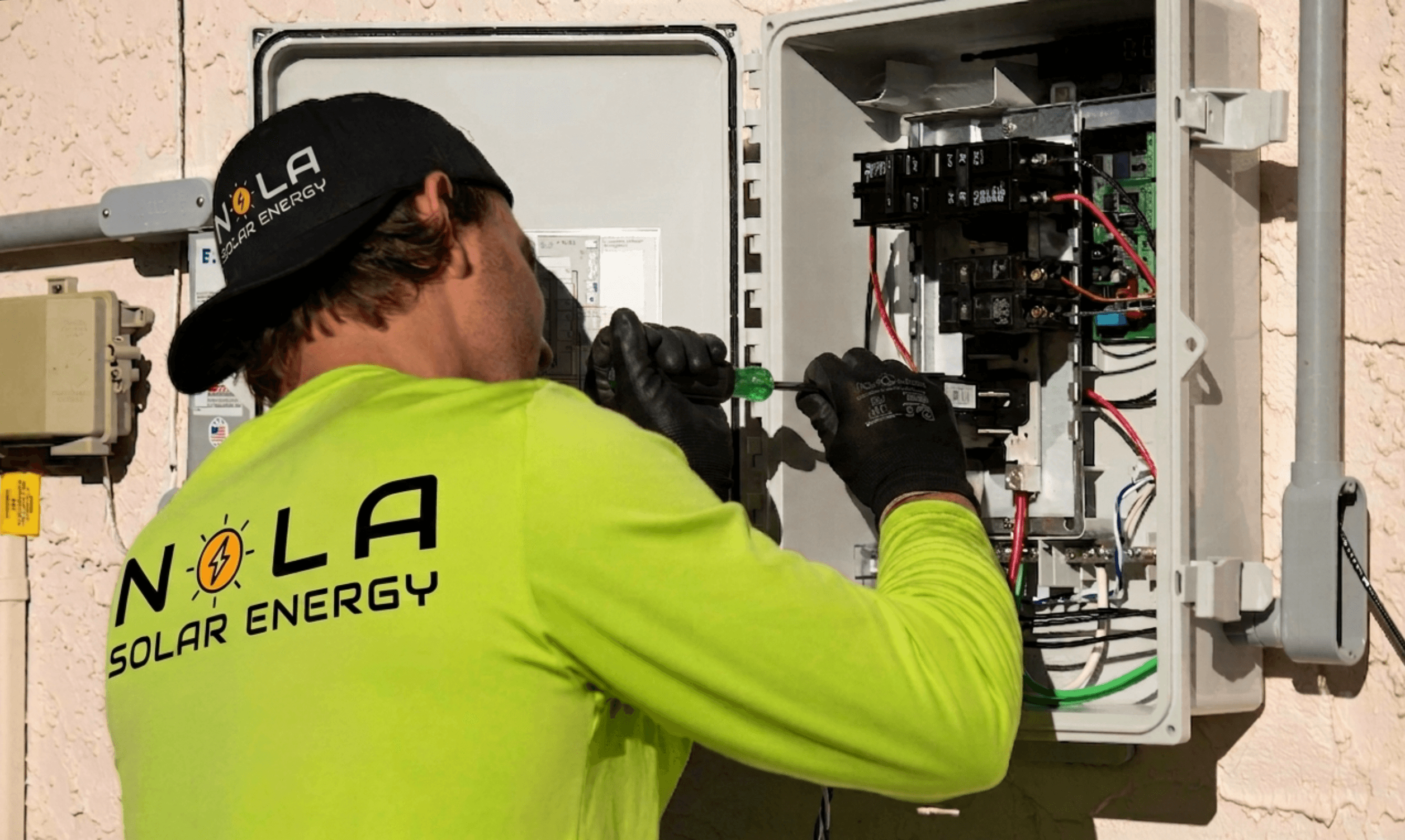 Solar technician inspecting inverter and electrical equipment